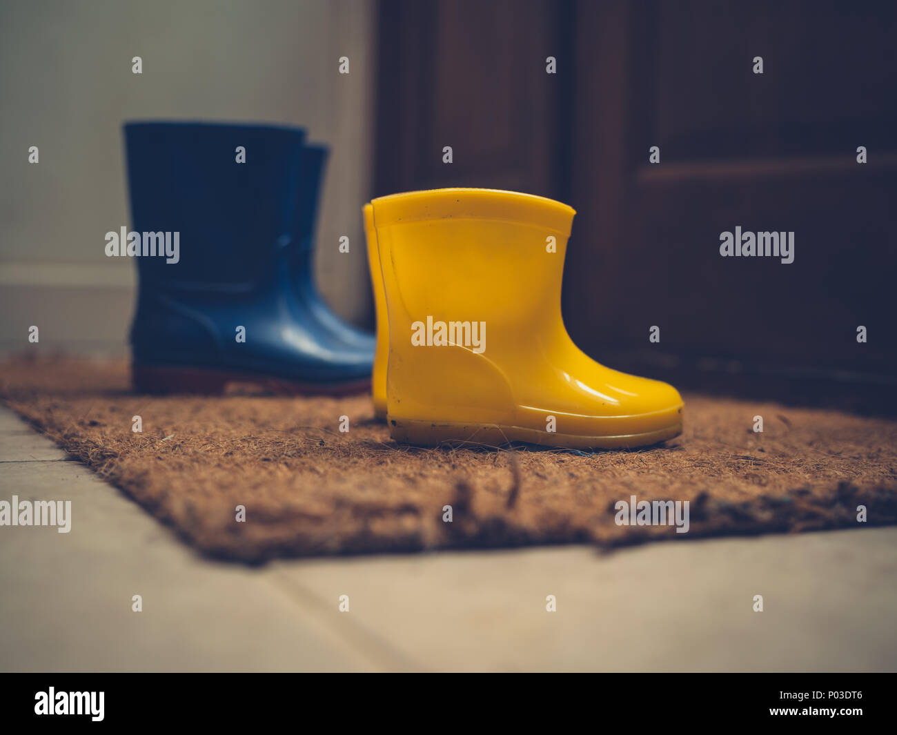 Zwei Paar Gummistiefel durch eine offene Tür Stockfoto