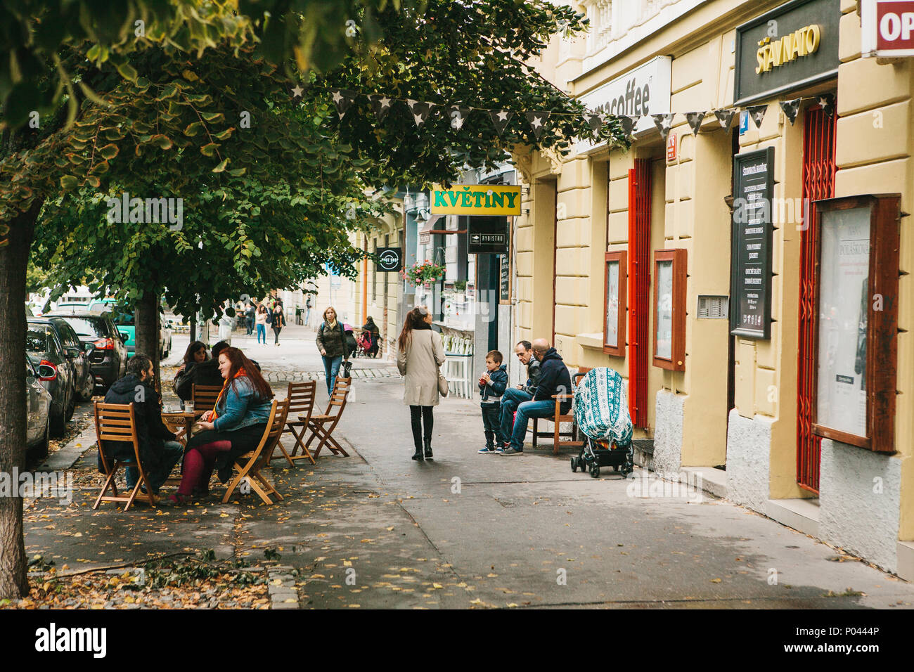 Prag, 24. September 2017: Die üblichen Leben der Anwohner in der Tschechischen Republik. Eine Gruppe von Menschen in einem Straßencafe sitzen und Reden, Fußgänger sind zu Fuß entlang der Straße. Stockfoto