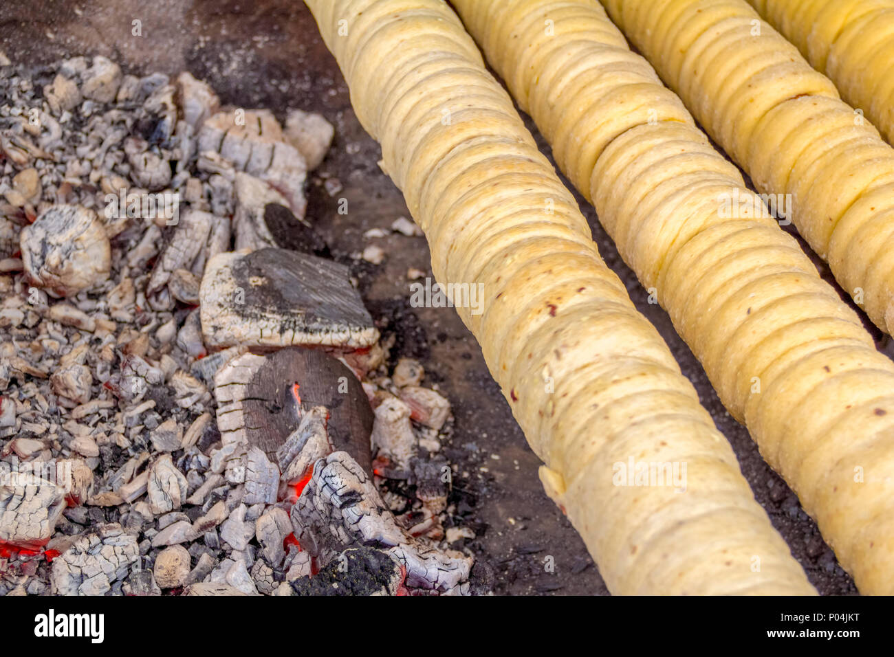 Meist zentralen europäischen Spieß Kuchen Spezialität namens Trdelnik drehen auf einem Grill in der Tschechischen Republik gesehen Stockfoto