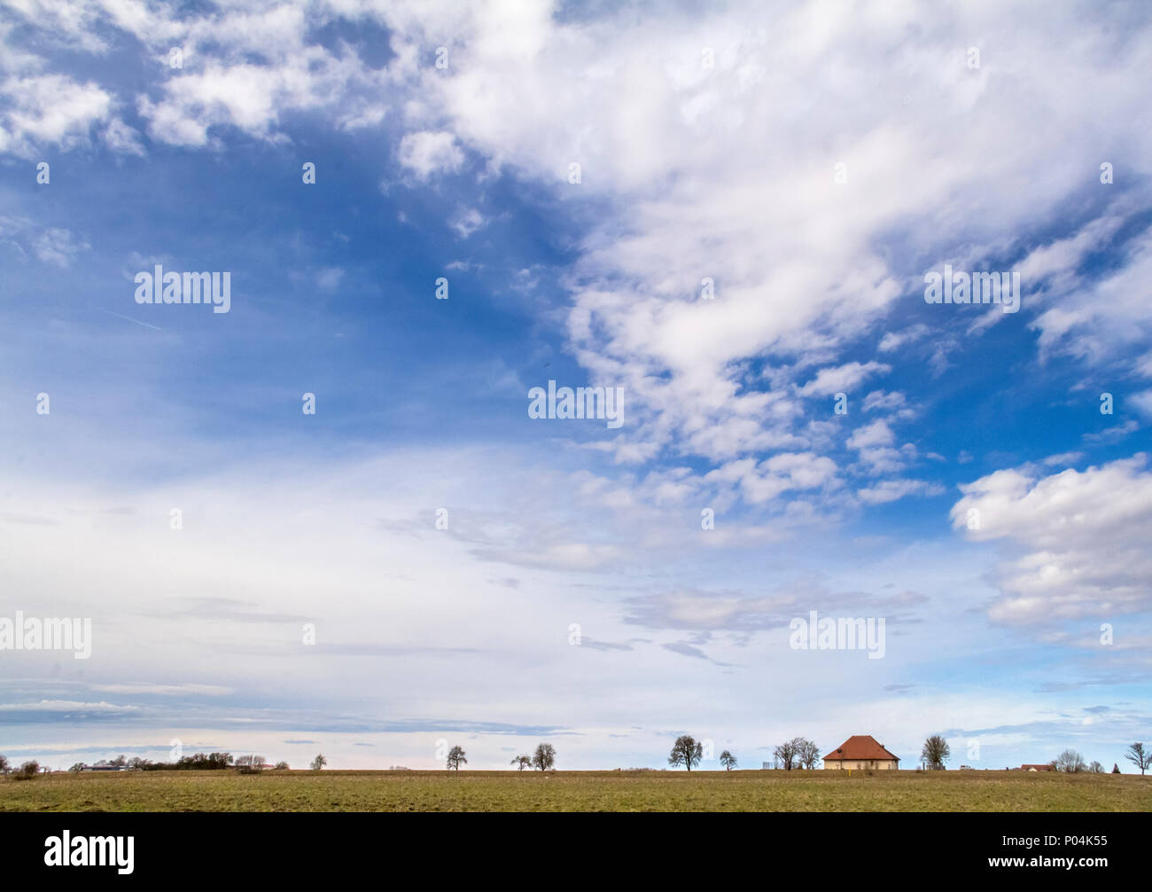 Viele teils bewölkte Himmel und kleine ländliche Landschaft im frühen Frühling in Süddeutschland Stockfoto