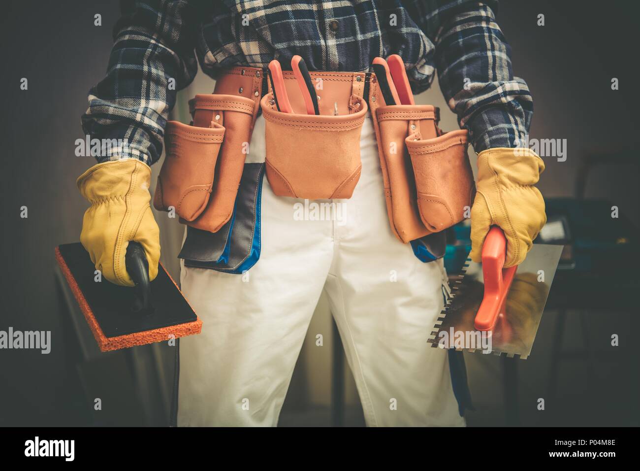 Bauunternehmen auf Aufgabe Konzept Foto. Arbeitnehmer mit großen Werkzeugen Riemen und einige Werkzeuge in den Händen. Stockfoto