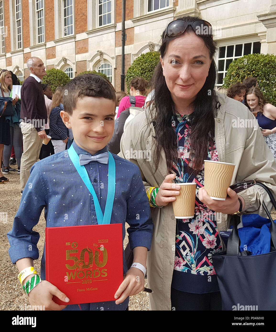 Fionn McCann, 9 Jahre alt, der als einer der Gewinner der diesjährigen 500 Wörter Kurze geschichte Wettbewerb mit seiner Mutter Ann bei der Live-übertragung des letzten im Hampton Court Palace in East Molesey. Stockfoto