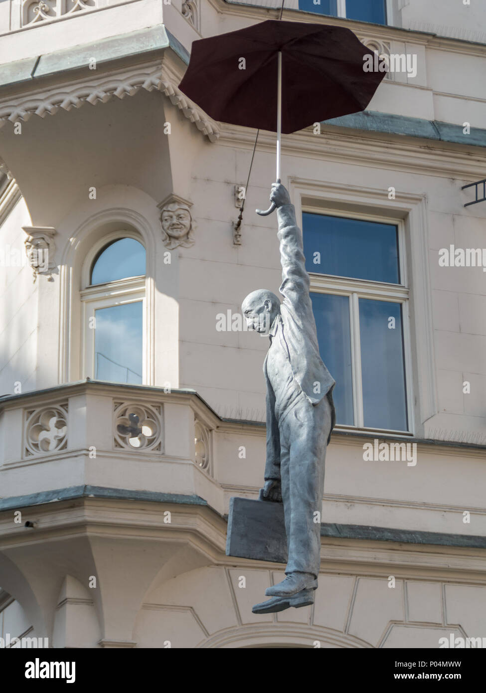Hängende Mann mit einem Regenschirm, ausgesetzt auf einem Kabel - Skulptur namens leichte Unsicherheit von Michal Trpak. Prag, Tschechische Republik Stockfoto