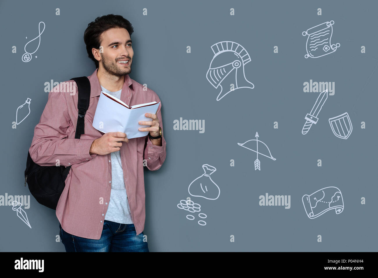 Junge Lehrer Lächeln beim Lesen ein historischer Roman Stockfoto