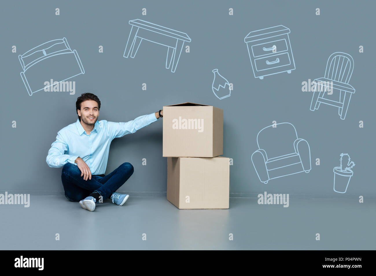 Glückliche Menschen in einem Wohnzimmer sitzen nach dem Umzug in eine neue Wohnung Stockfoto