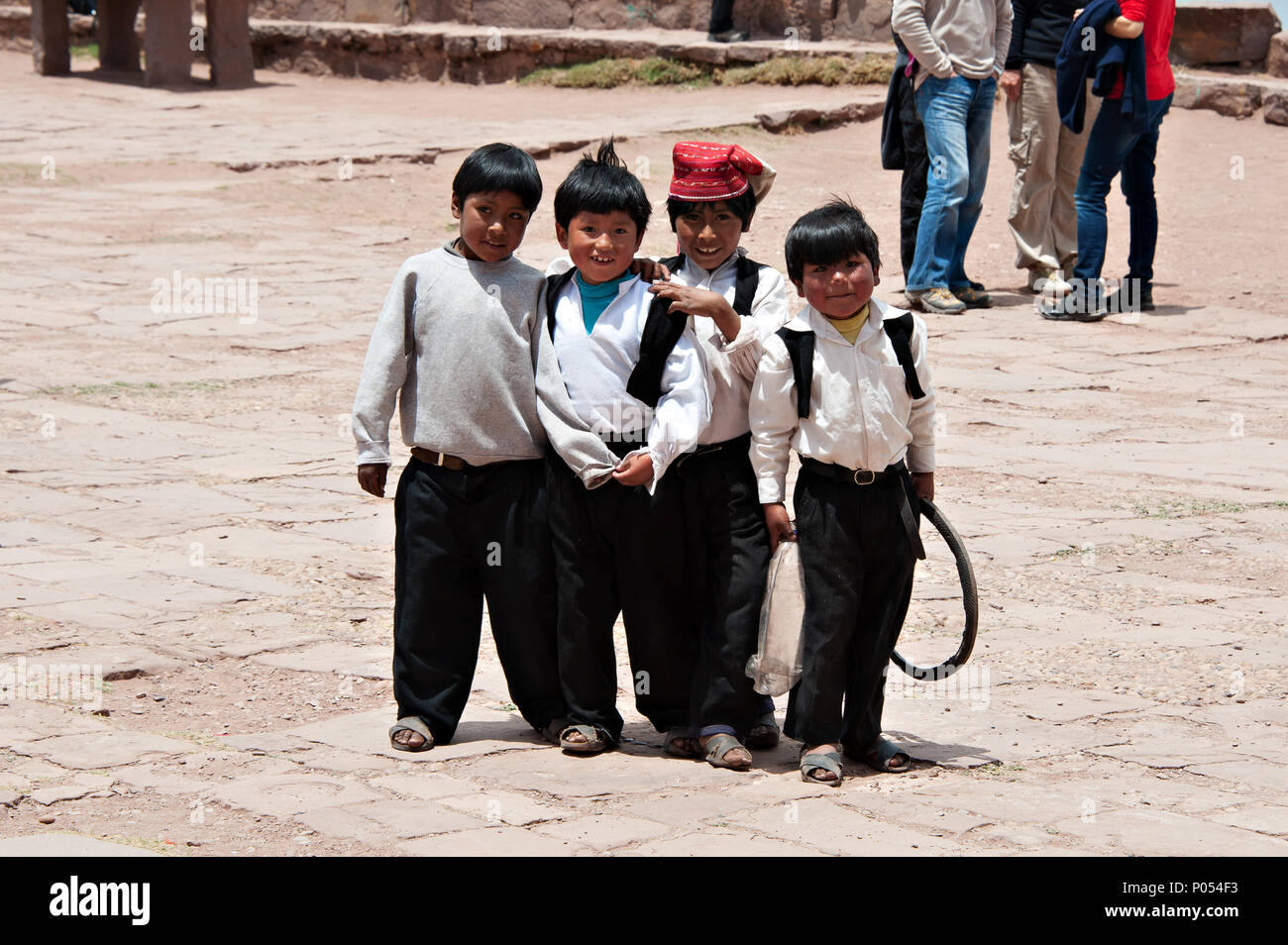 Jungen jungen Runde für ein Foto im Austausch für Süßigkeiten und Bonbons in das Dorf in der Insel Taquile zu Stellen sammeln, den Titicacasee. Peru Stockfoto