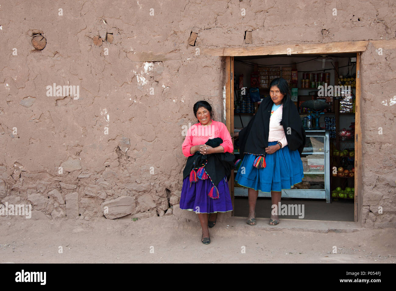 Zwei lokale Frauen in traditionellen peruanischen Röcke für eine photograoph außerhalb ihrer Shop auf Taquile Insel darstellen, den Titicacasee. Peru Stockfoto