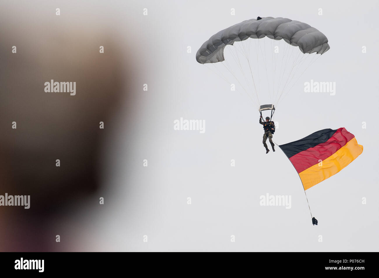 Wunstorf, Deutschland, 09. Juni 2018, ein Fallschirmjäger mit einem deutschen Flagge landet auf der Air Base nach dem Sprung von einem Airbus A400M-Transporter. Der vierte "Tag der Bundeswehr" ist eine deutsche militärische Ereignis bundesweit an 21 verschiedenen Standorten. Foto: Swen Pförtner/dpa Quelle: dpa Picture alliance/Alamy leben Nachrichten Stockfoto