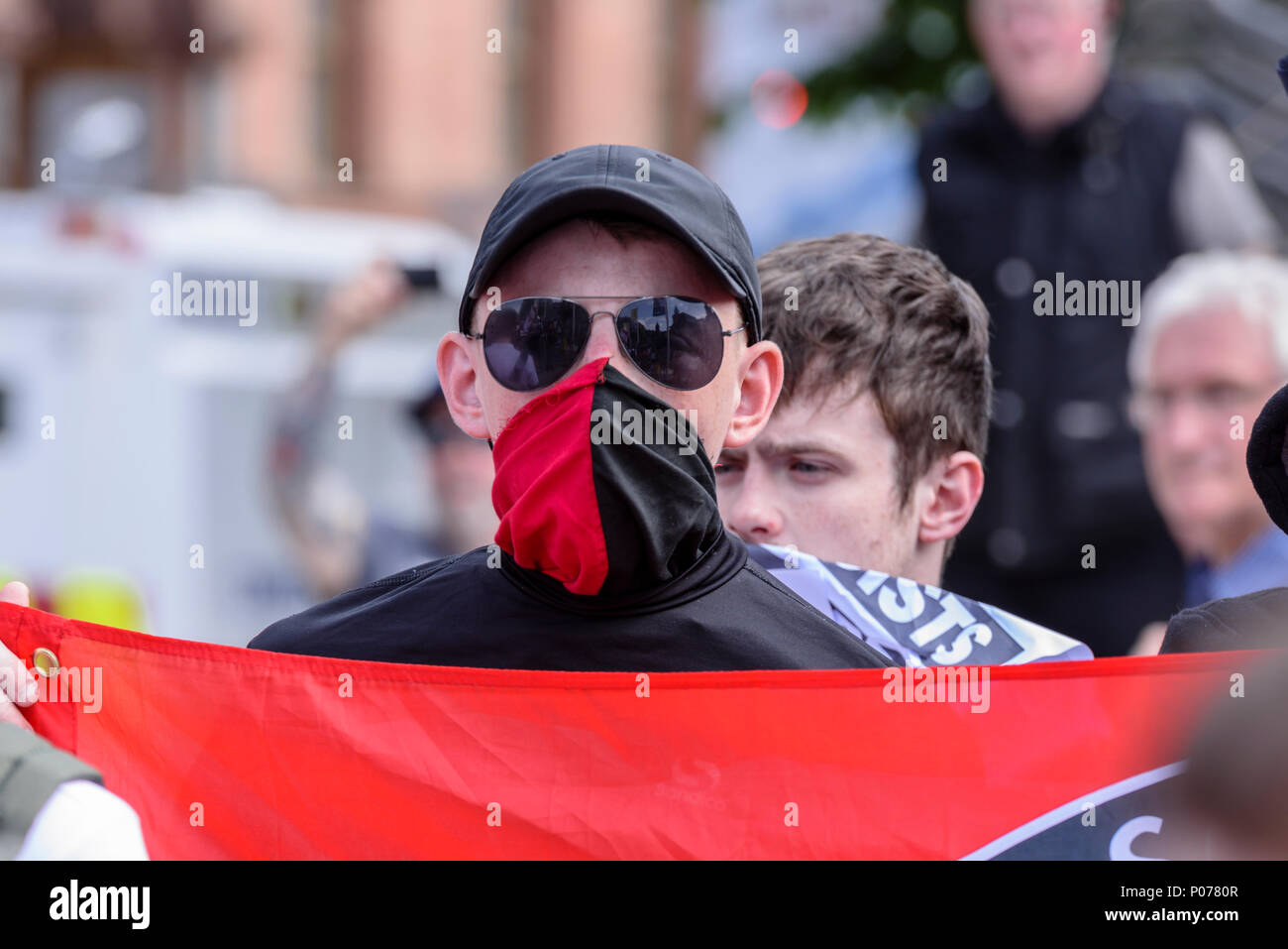 Belfast, Nordirland. 09/06/2018 - Nordirland Antifa-Mitglieder, viele mit ihren verdeckten Gesichtern, Protest gegen eine Kundgebung zur Unterstützung der britischen Ersten Tommy Robinson, die im Mai 2018 für Missachtung des Gerichts gefangengesetzt. Stockfoto