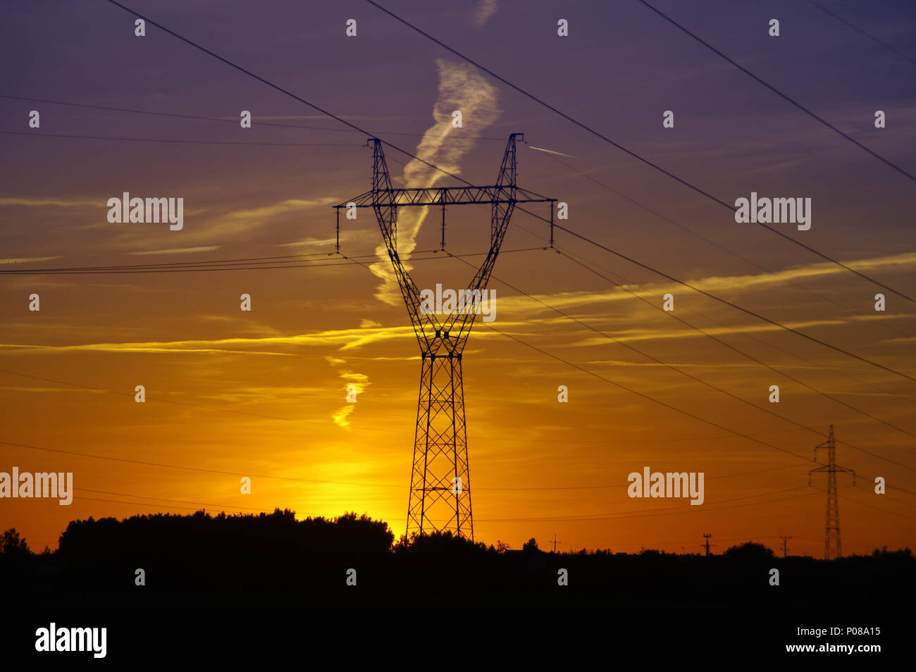 Elektrische Turm Silhouette am Sonnenuntergang. Hohe Spannung Energie Linie auf orange sky. Stockfoto