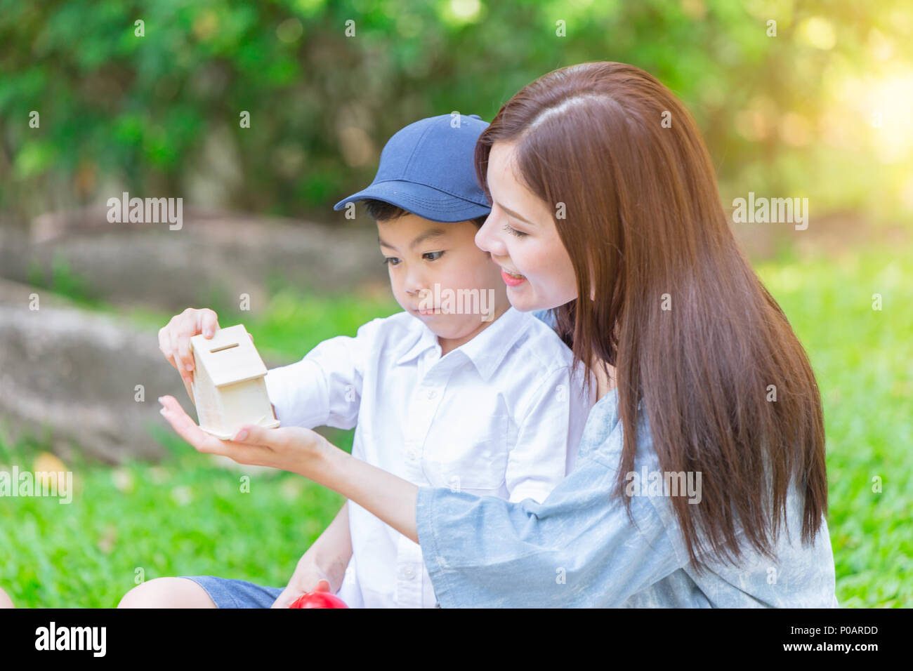Schöne asiatische Mutter spielt mit ihrer schönen Sohn im Green Park Stockfoto