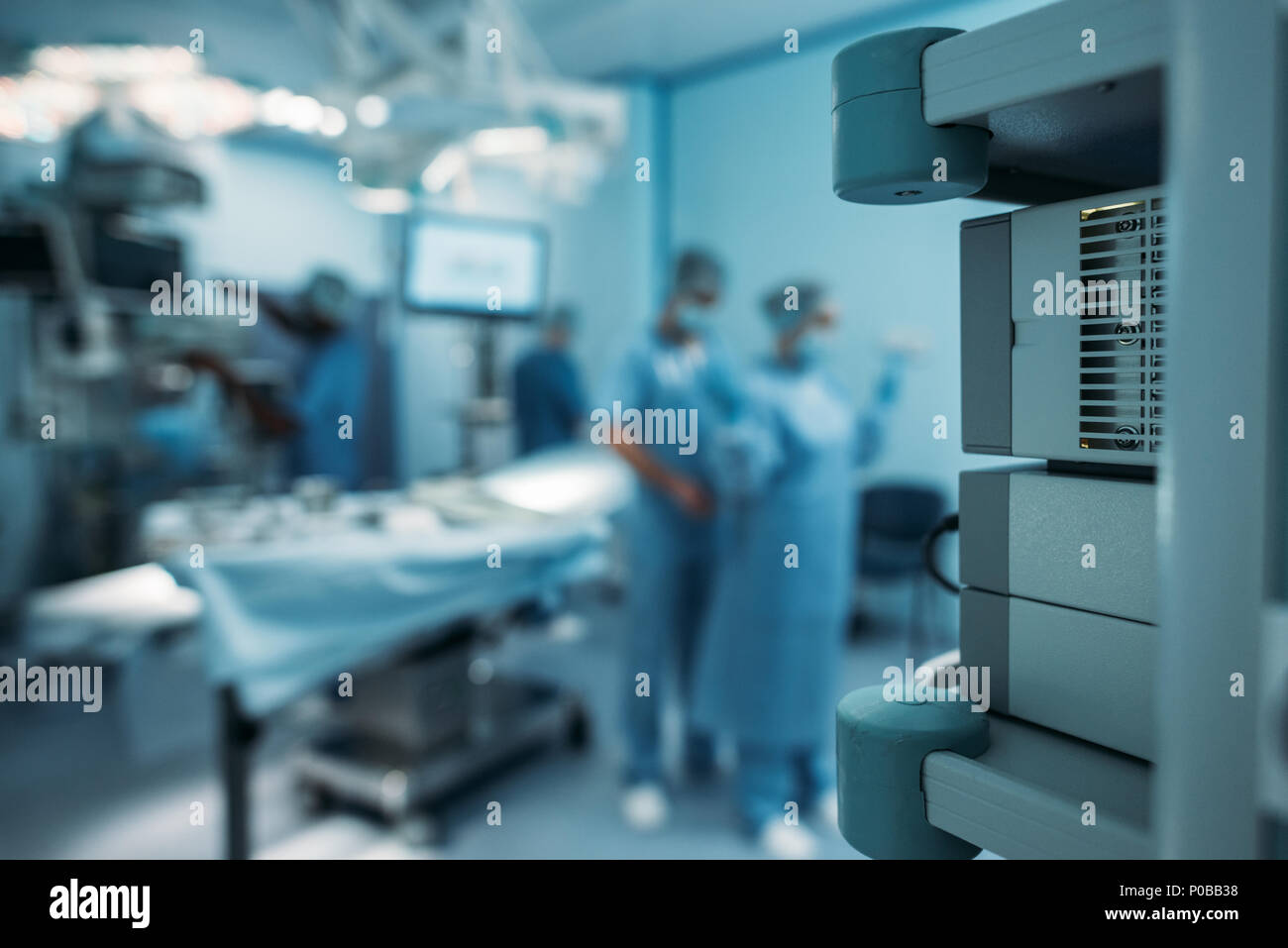 Arzt helfen chirurgische Uniform auf unscharfen Hintergrund zu tragen Stockfoto