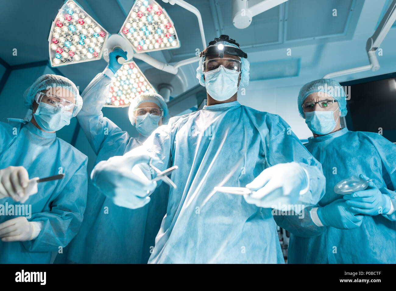 Ansicht von unten auf das multikulturelle Chirurgen mit medizinischen Instrumente während der Operation Stockfoto