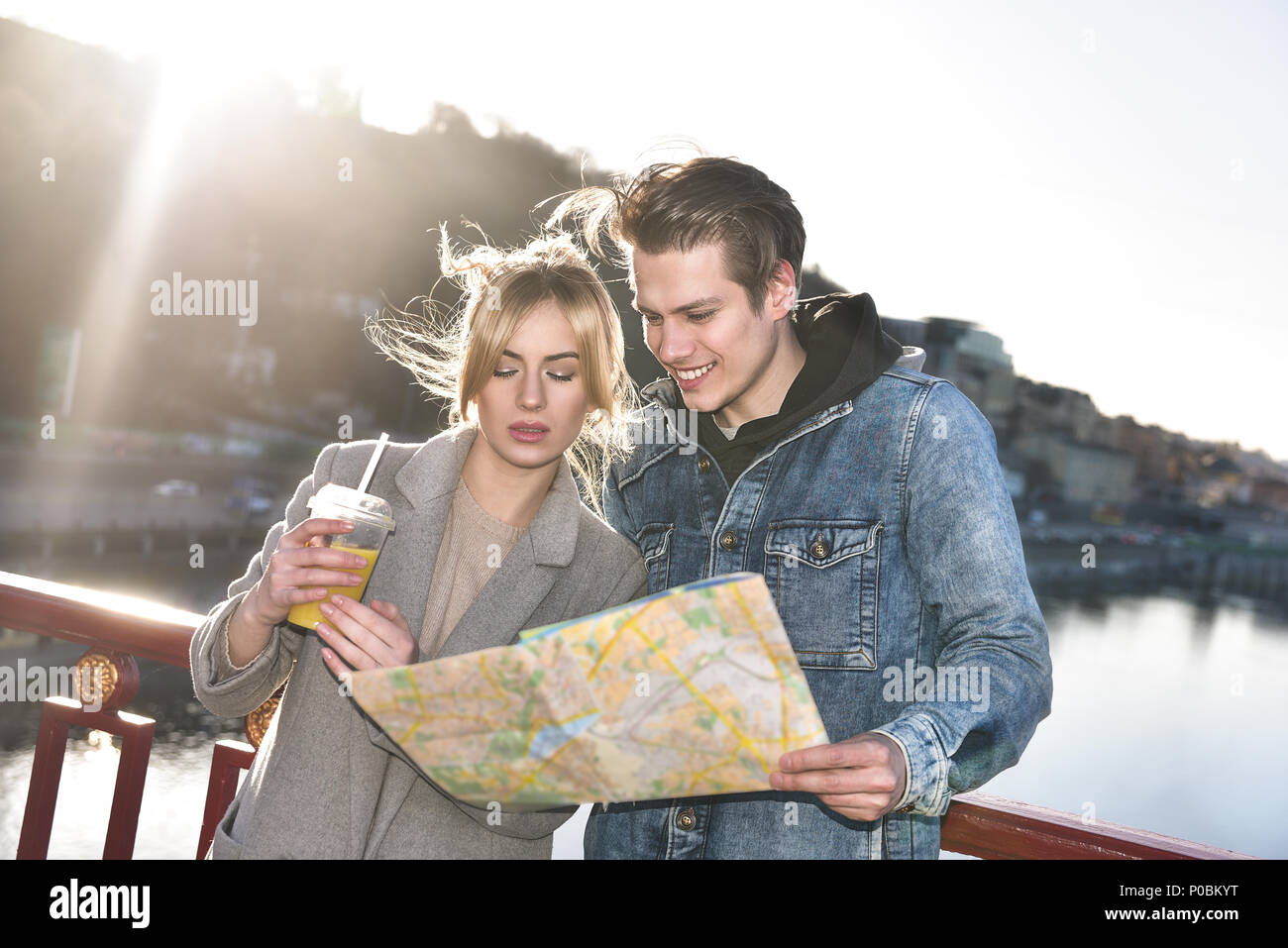 Eine schöne junge touristische Paare sind auf der Brücke stehen und um suchen Stockfoto