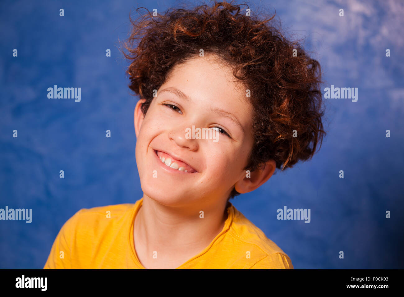 Close-up Portrait von Jugendlichen lockige Junge lächelnd und mit Blick auf die Kamera Stockfoto