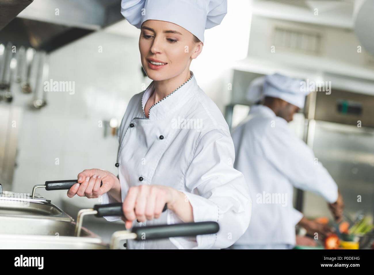 Attraktive Koch Frittieren in Öl bei Restaurant Küche Stockfoto