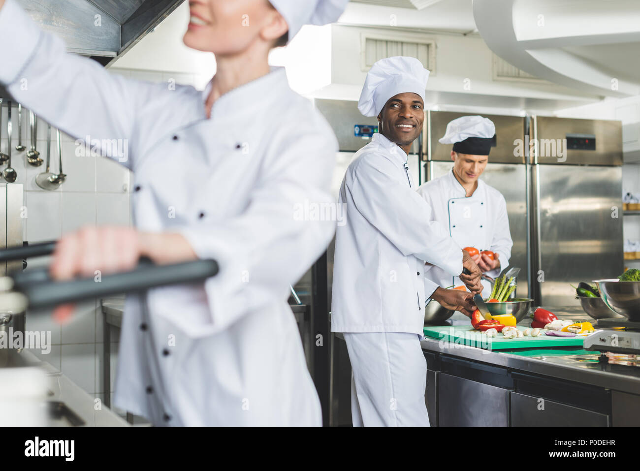 Lächelnd multikulturellen Köche kochen im Restaurant Küche Stockfoto
