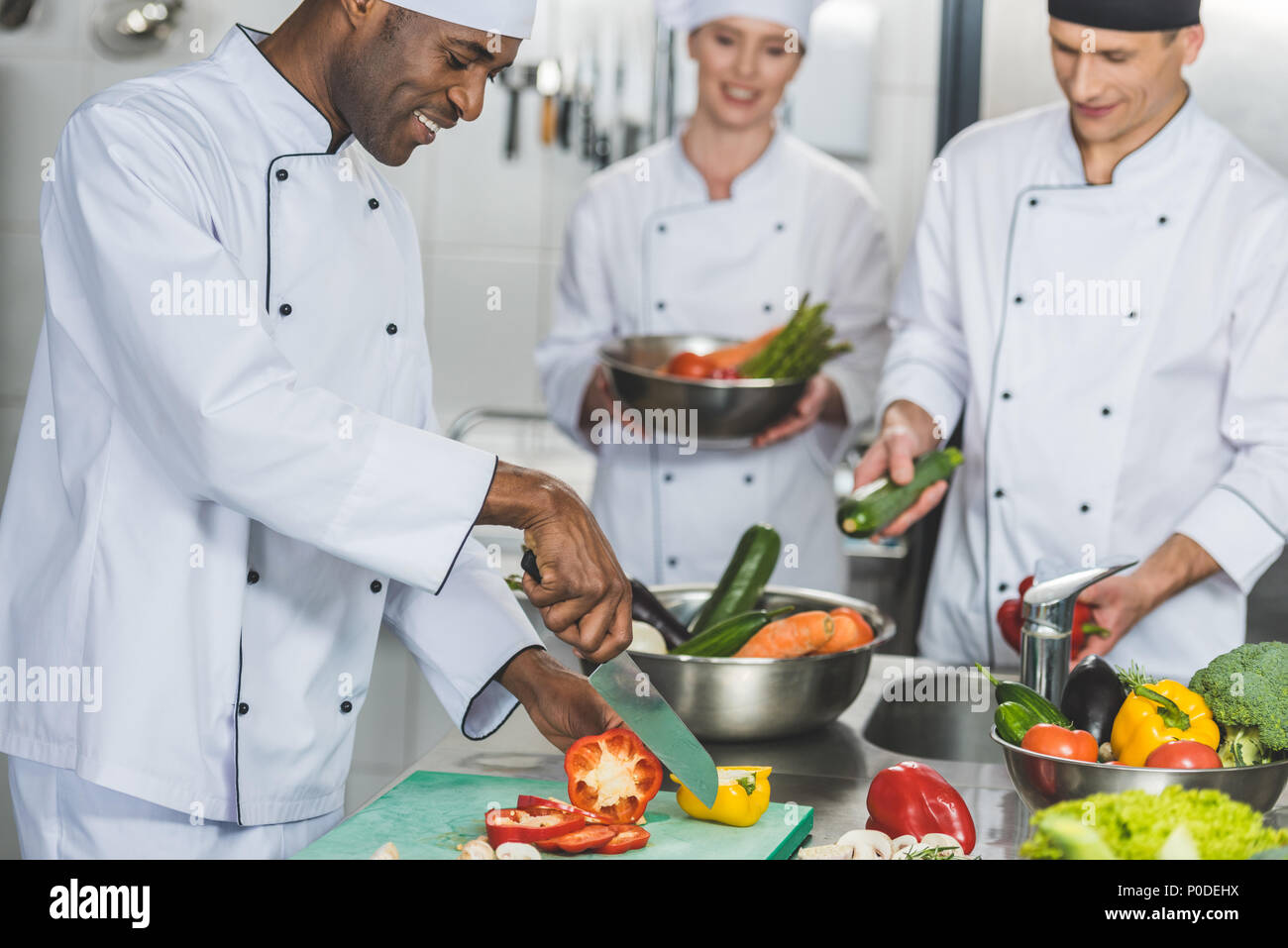 Multikulturelle Köche kochen Salat im Restaurant Küche Stockfoto