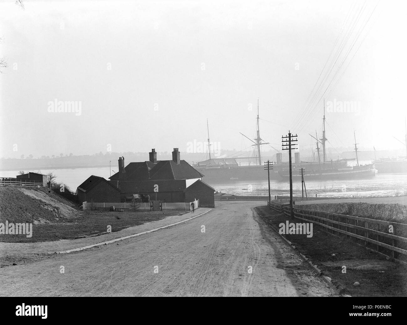 . Englisch: Ein Blick über das Vorland des hotley Gate suchen" über den Fluss Stour in Richtung Harwich Blick nach unten eine leichte Steigung auf das Vorland des hotley Gate' über den Fluss Stour in Richtung Harwich. Die Bristol Arme ist auf der linken Seite der Straße mit Blick auf den Fluss. Die Ausbildung von Schiffen" Ganges', (ex-'Minotaur") (1863), und 'Caroline' (1882) und das Heck Quartal 'Ganges II' (ex-'Agincourt") (1865) in der Mitte bei moorings gesehen werden kann. Ein Blick auf das Vorland des hotley Gate suchen" über den Fluss Stour in Richtung Harwich. ca. August 1907. Smiths Suitall Ltd 241 eine Vie Stockfoto