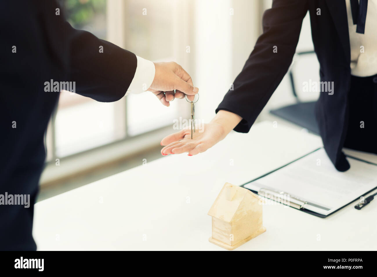 Immobilienmakler geben Schlüssel zum Eigentümer der Wohnung, Kauf Verkauf von Immobilien. Nahaufnahme von Frau Hand die Hausschlüssel von Realtor. Hypothek für Stockfoto