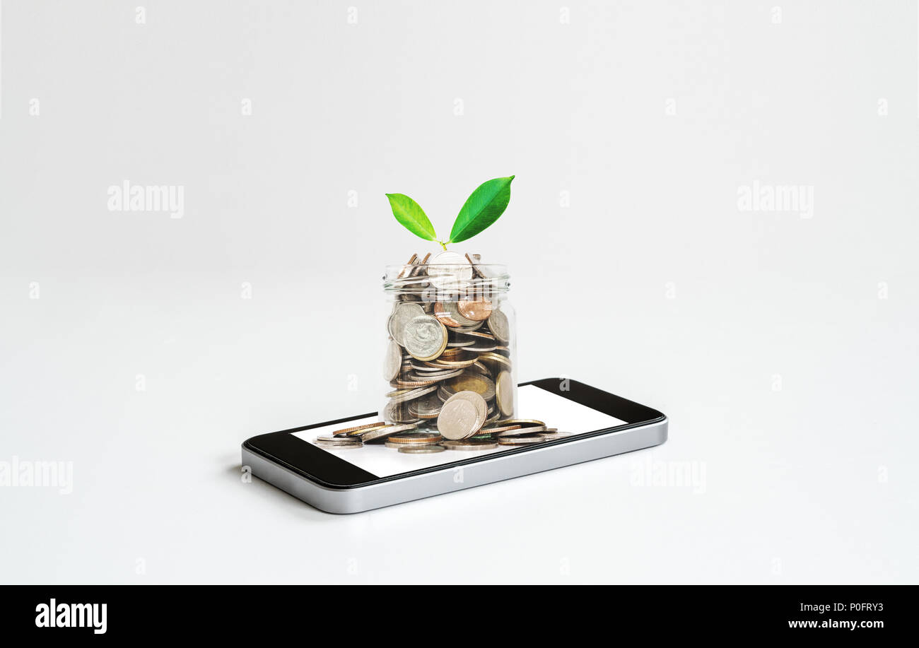 Online Banking und Geld verdienen durch Online- Business und e-Commerce. Handy und Glas Glas voller Münzen Stockfoto