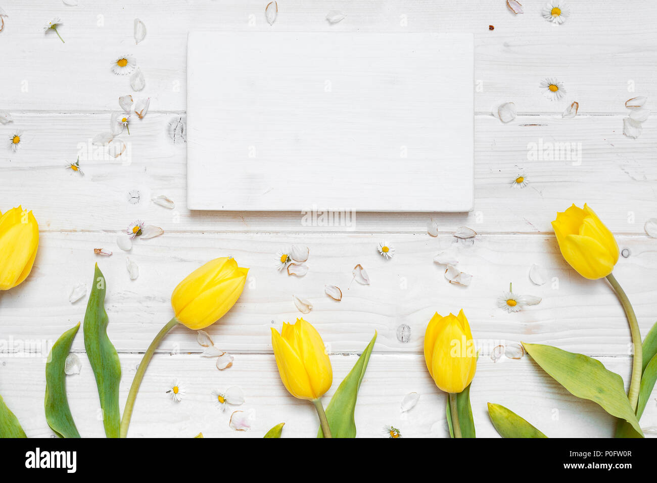 Weiße Tischplatte Szene mit gelben Tulpen und leere Rahmen aus Holz Stockfoto