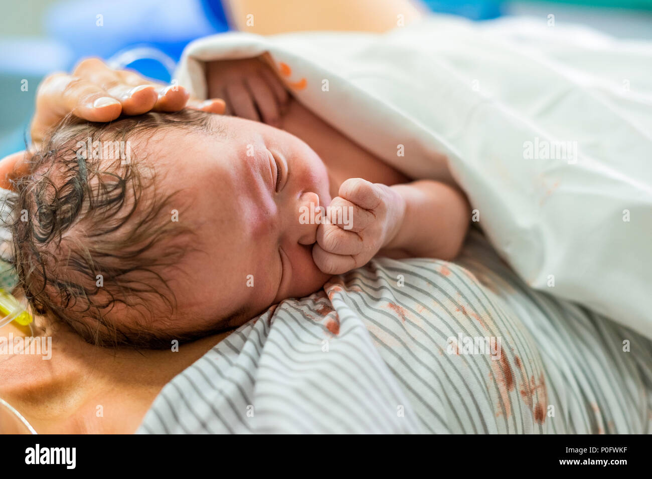 Neugeborenes Baby Boy zur Festlegung auf seine Mama mit ihr gepolsterte Hand auf ihn Stockfoto
