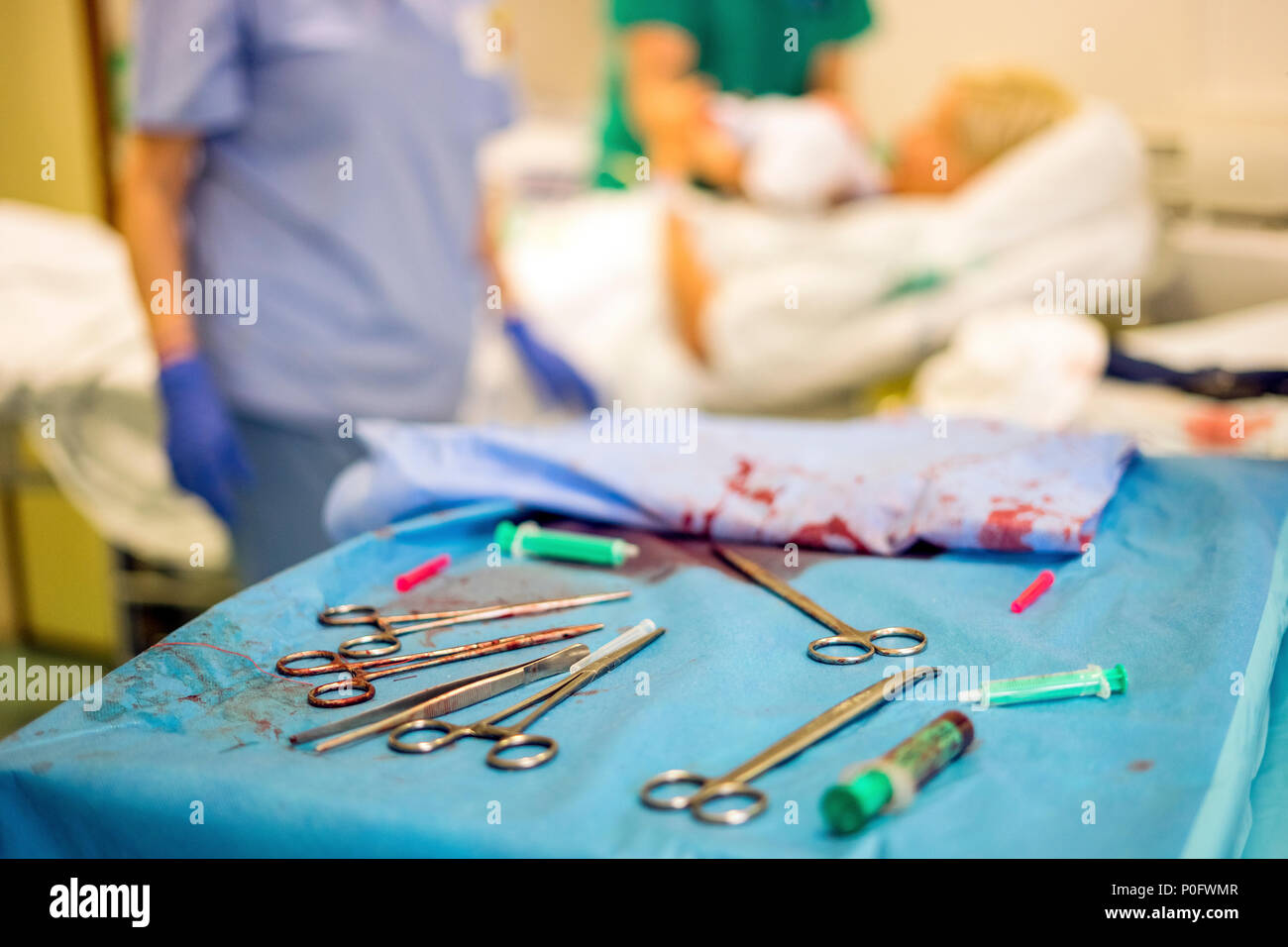 Silver Frauenarzt Werkzeuge während der Geburt und die Mutter und das Krankenhauspersonal im Hintergrund verwendet Stockfoto