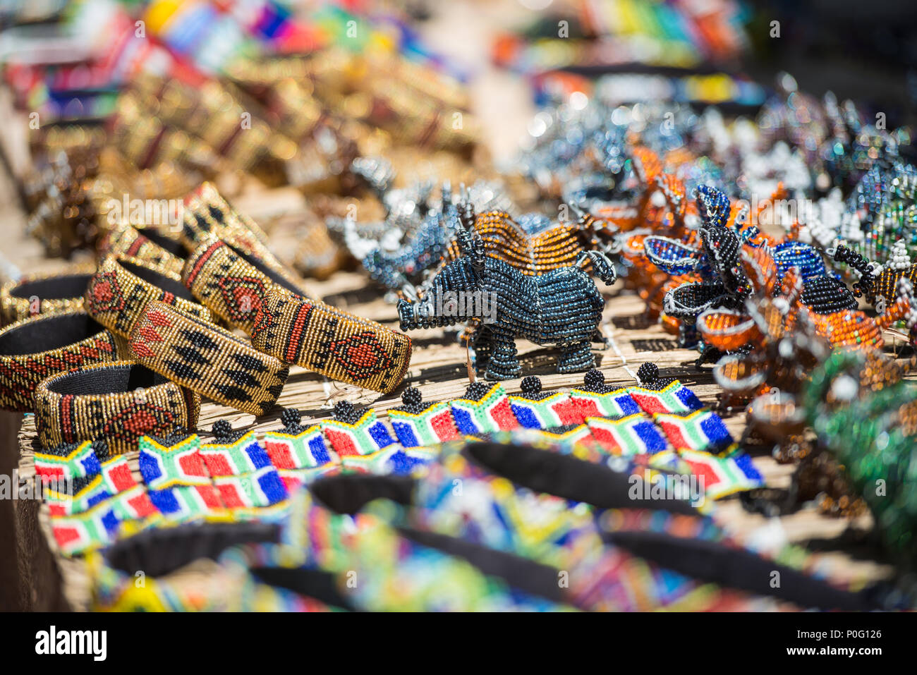 Bunte Südafrikanische Raupe Kunst in Armbänder, Nashörner und Flusspferde im freien Markt Stockfoto