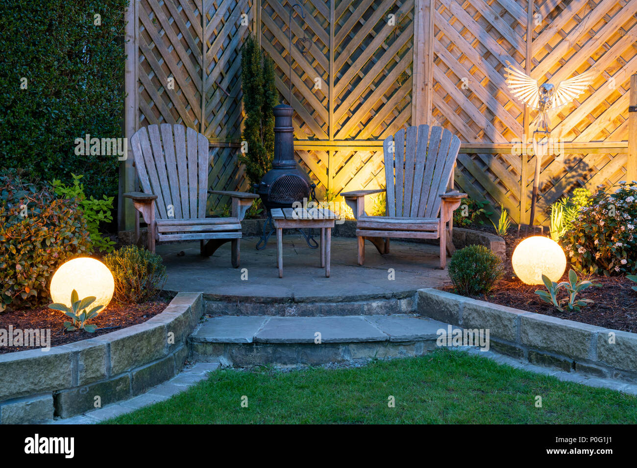 Schönen, gepflegten, privaten Garten mit zeitgenössischem Design, Grenzen & Terrasse von Globe Leuchten in der Dämmerung - Yorkshire, England, Großbritannien beleuchtet. Stockfoto
