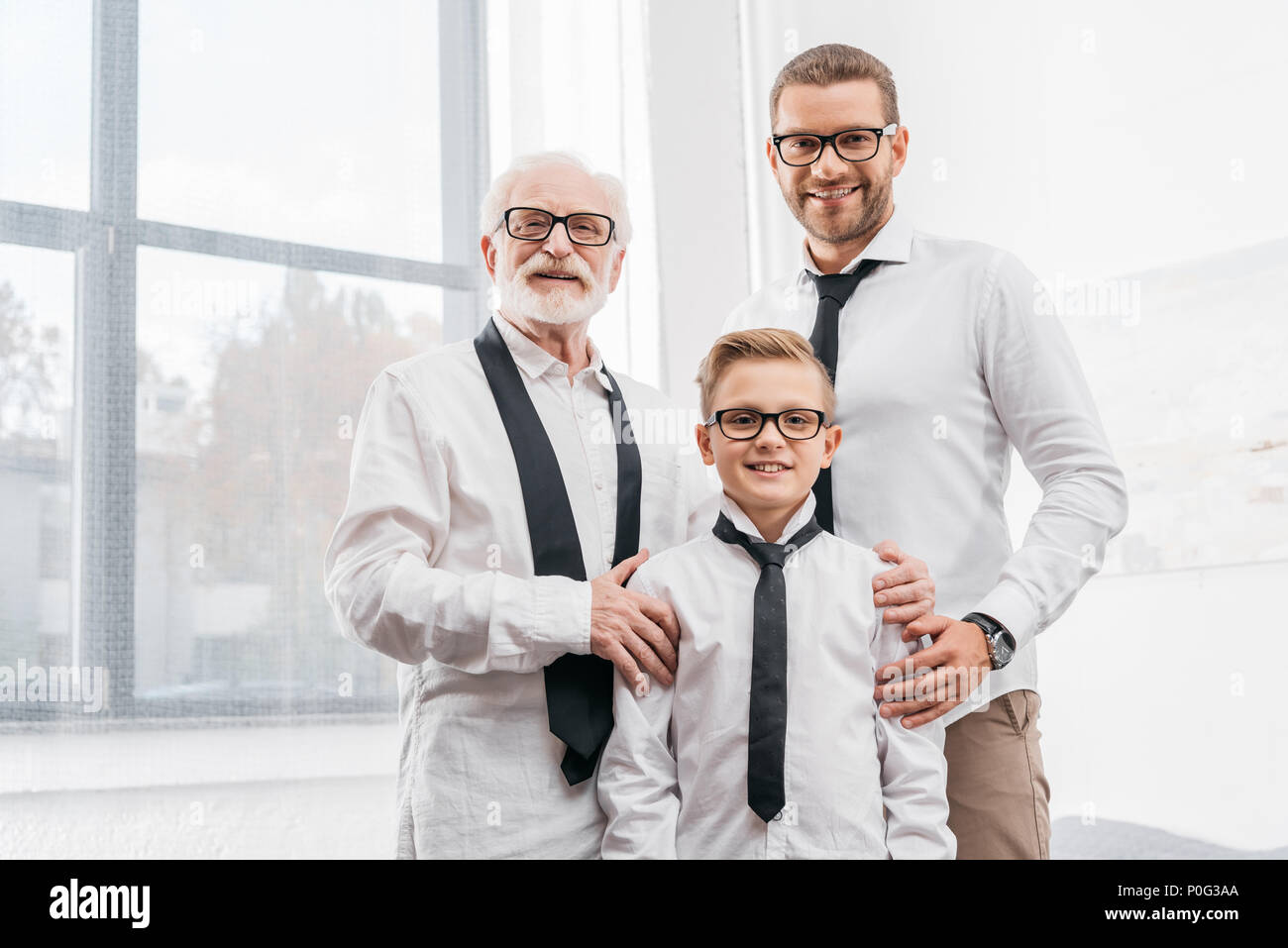 Vater, Sohn und Großvater formelle Kleidung tragen, zusammen stehen und von der Kamera Stockfoto