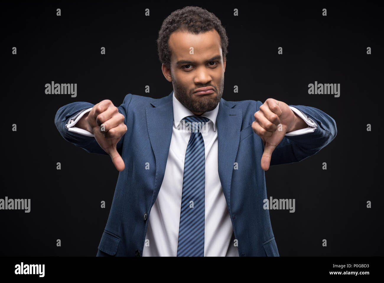 Portrait von umgekippt afro-amerikanische Geschäftsmann Gestik Daumen unten Zeichen isoliert auf Schwarz Stockfoto