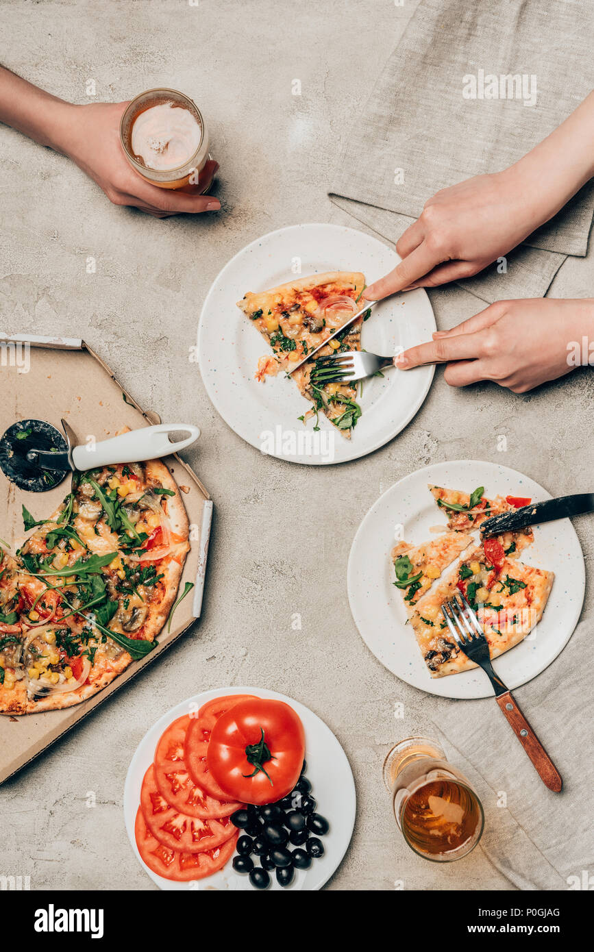 Nahaufnahme der Freunde teilen Pizza und Getränk auf hellen Hintergrund Stockfoto