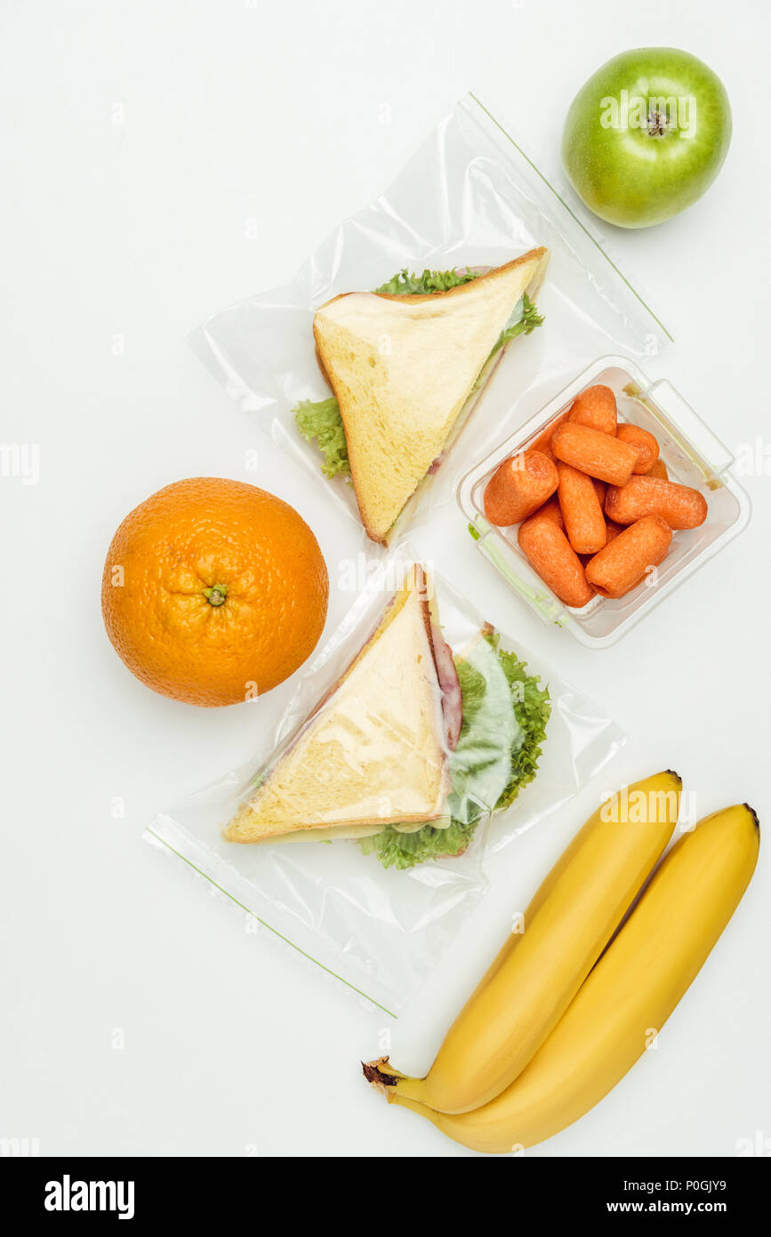 Blick von oben auf die Früchte und Sandwiches in ziplockbeutel isoliert auf weißem Stockfoto