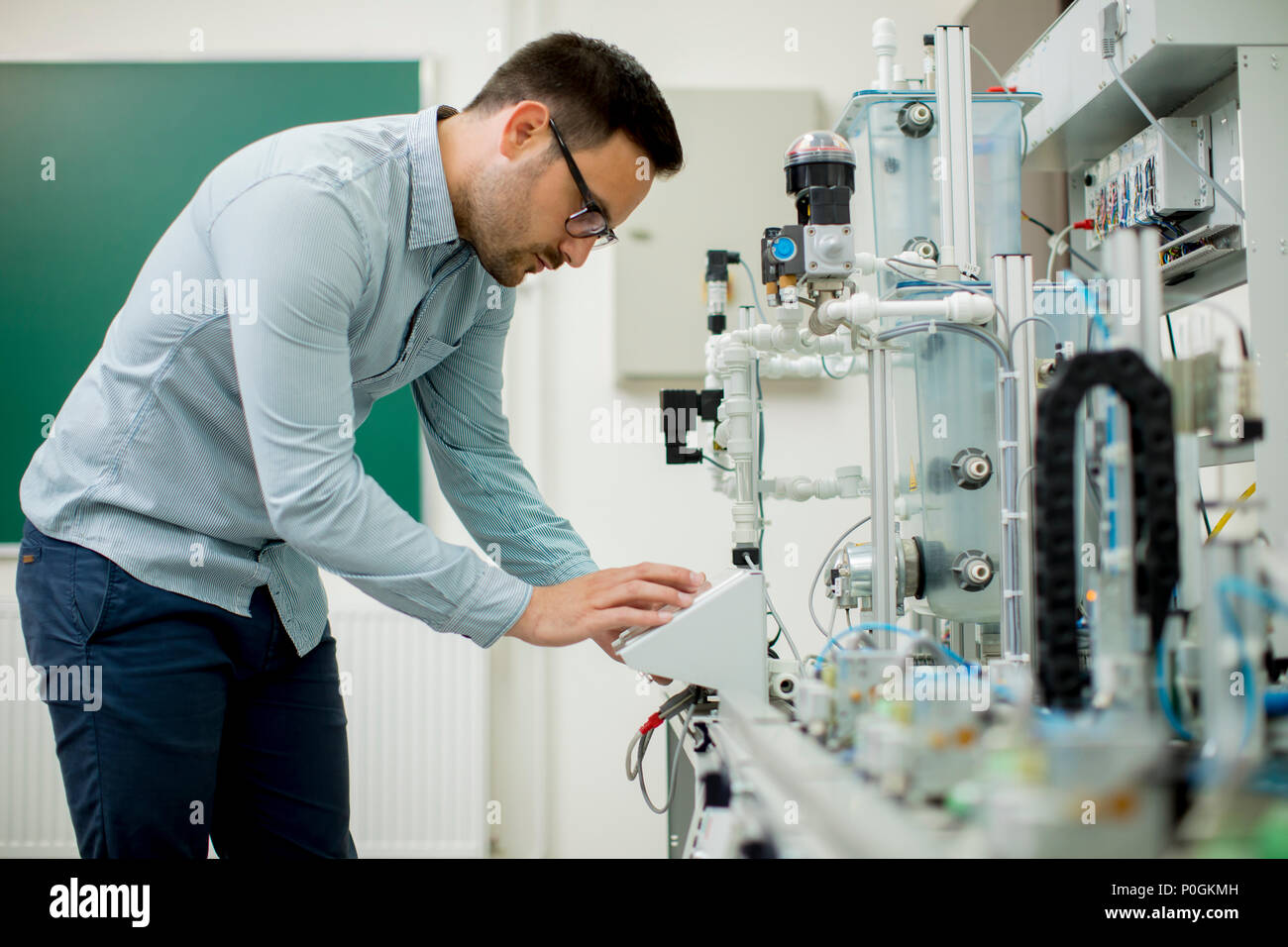 Hübscher junger Mann, der in der elektronischen Werkstatt Stockfoto