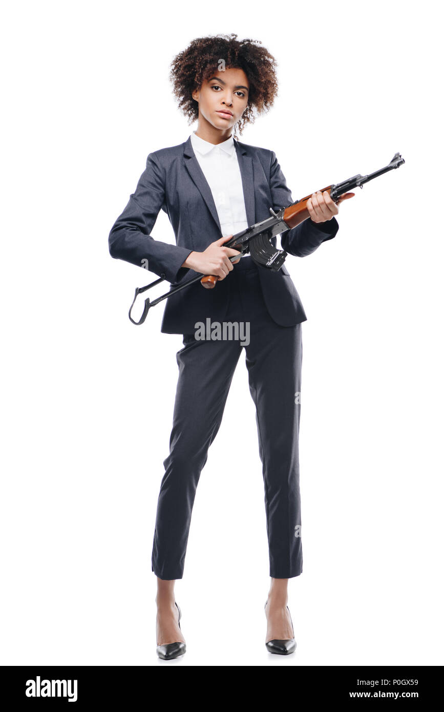 Afrikanische amerikanische weibliche Secret Agent im Anzug mit Gewehr posiert, isoliert auf weißem Stockfoto