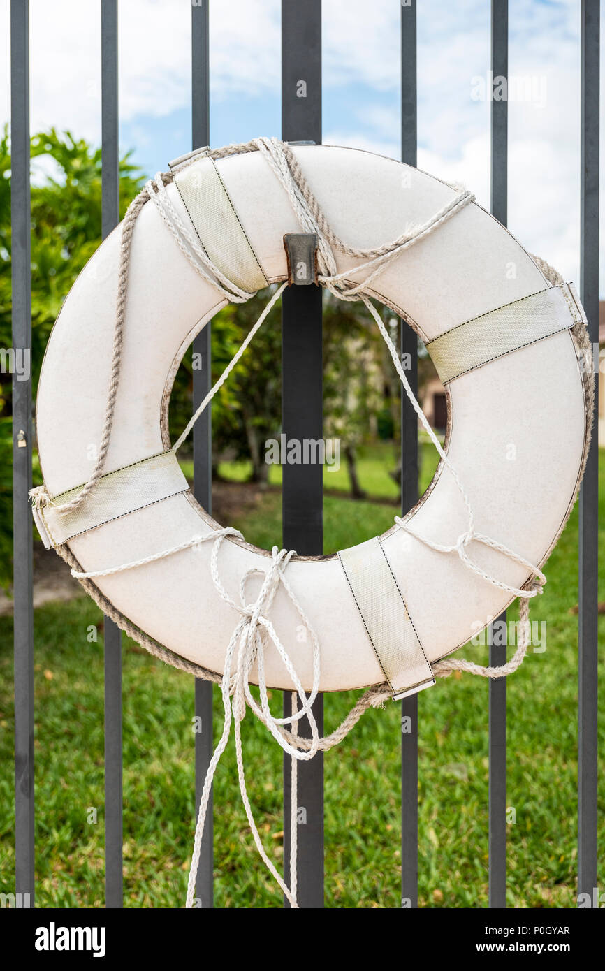 Schwimmweste am Zaun neben dem Außenpool; South Central Florida, USA Stockfoto