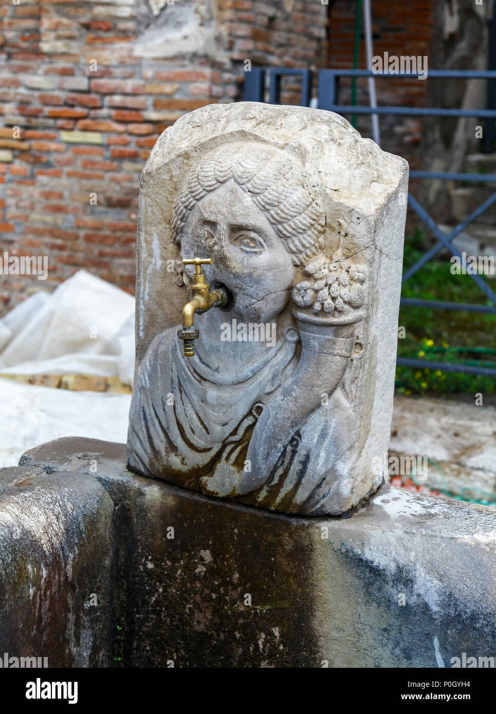 Ein Leitungswasser aus dem Mund eines steinernen Brunnen in der Form einer Personen Kopf an der Ausgrabungsstätte von Pompeji, Pompei, Kampanien, Italien, Stockfoto