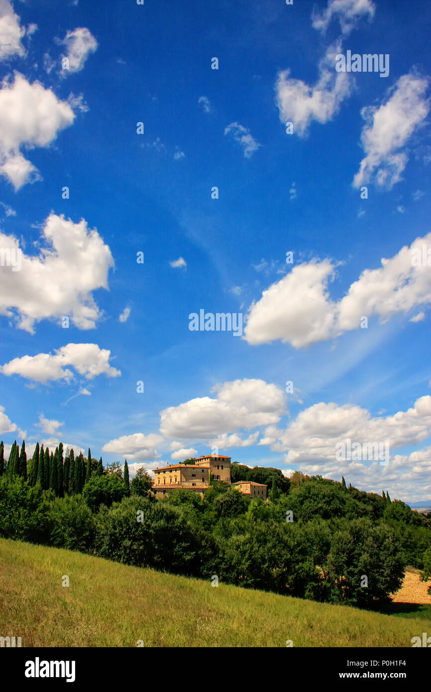 Haus von Bäumen im Val d'Orcia, Toskana, Italien umgeben. Im Jahr 2004 wird die Val d'Orcia wurde von der UNESCO in die Liste des Weltkulturerbes aufgenommen Stockfoto