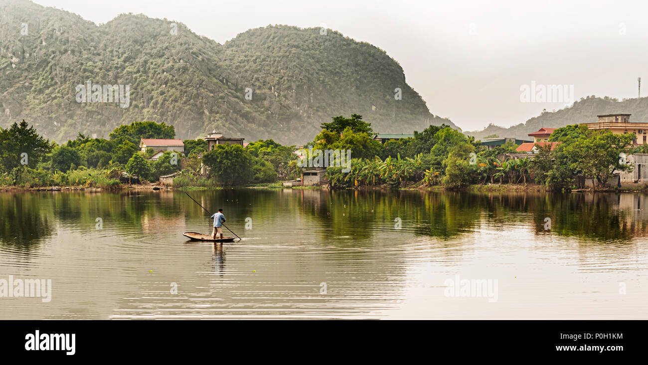 Hoa Lu, Vietnam - Oktober 28, 2017: der Mensch ist die Fischerei auf kleinen Beiboot in der See in Hoa Lu alte Hauptstadt von Vietnam. Stockfoto