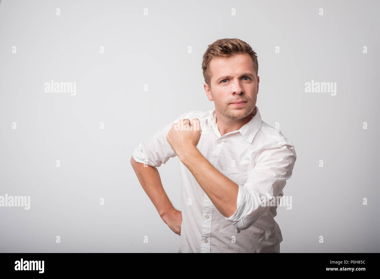 Selbstbewusst im mittleren Alter Mann im weißen Hemd mit einer geballten Faust Stockfoto