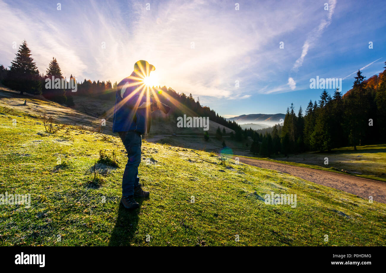 Fotograf in sunburst Schießen nebligen Landschaft. wunderschöne Landschaft von Apuseni Naturpark im Herbst bei Sonnenaufgang. wunderbares Abenteuer oder Job Konzept. Stockfoto