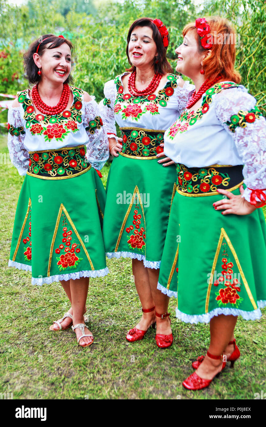 Drei ukrainische Damen in traditionellen gestickten Kostümen singen im August 2016 auf der Sorochintsi Agromesse in der Region Poltava in der Zentralukraine. Stockfoto