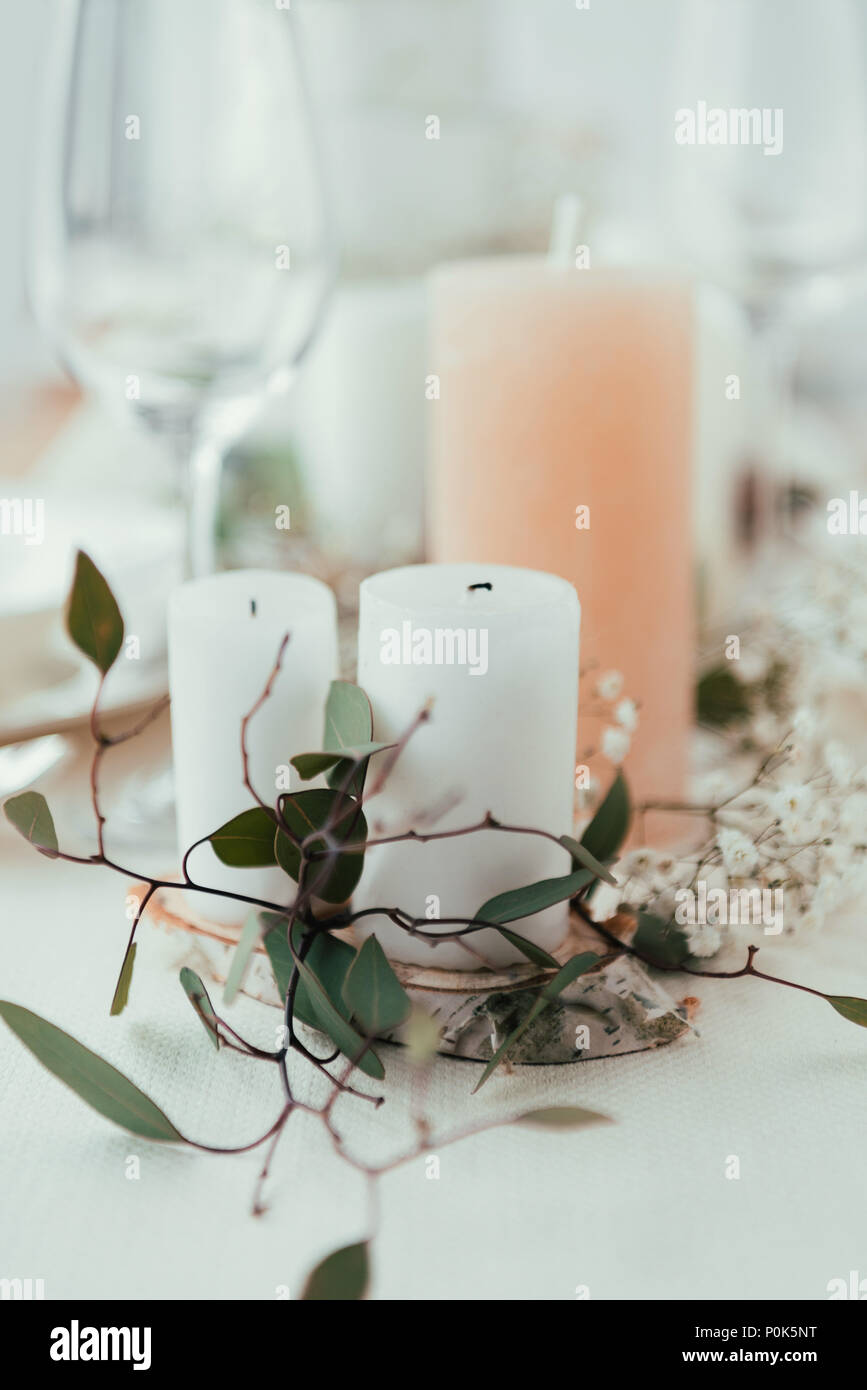 Die Nahaufnahme des stilvollen Tisch mit Kerzen, Blumen und Eukalyptus für rustikale Hochzeit Stockfoto