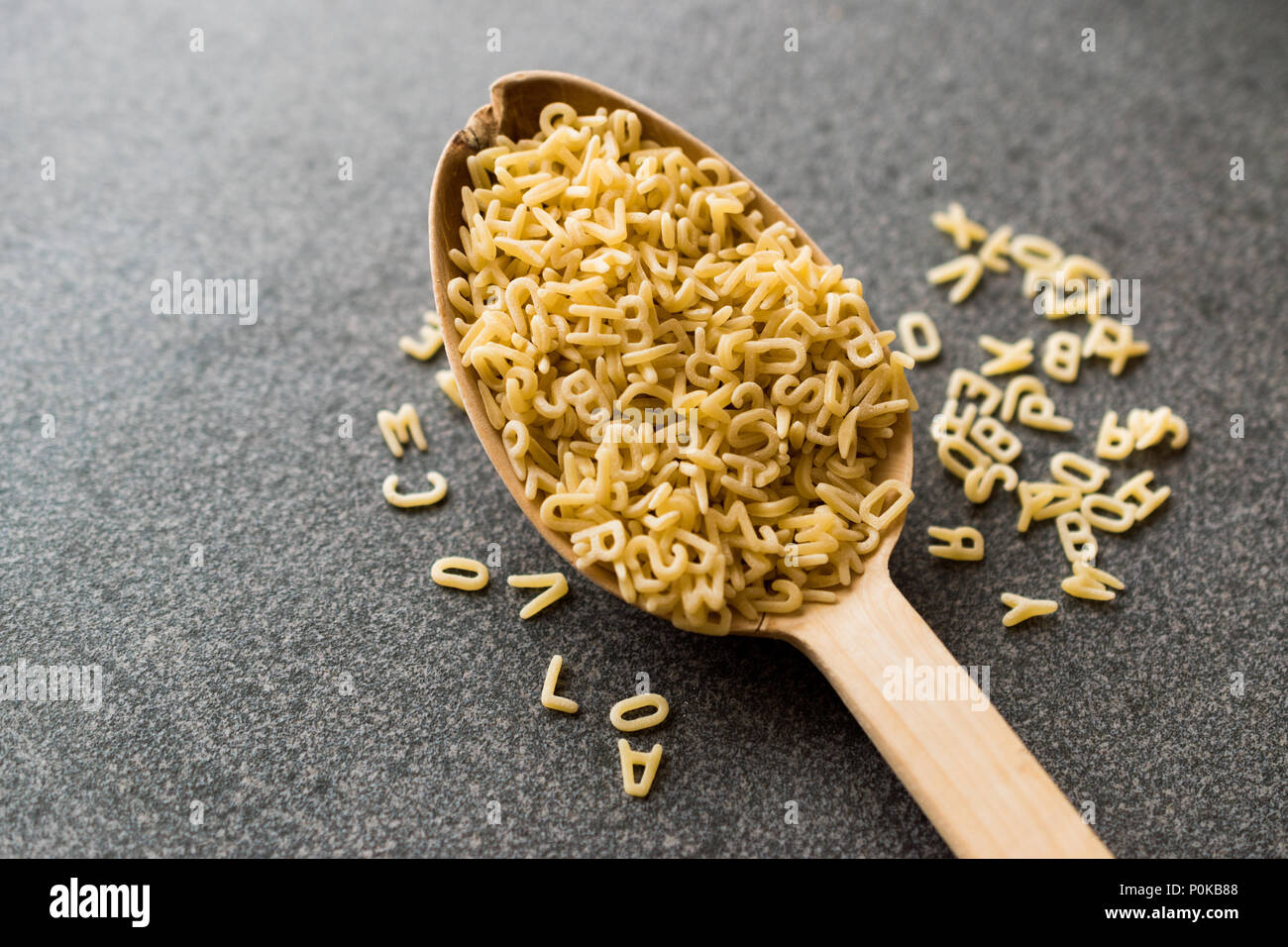 Roh ungekocht Alphabet Nudeln in Löffel aus Holz. Ökologische Lebensmittel. Stockfoto