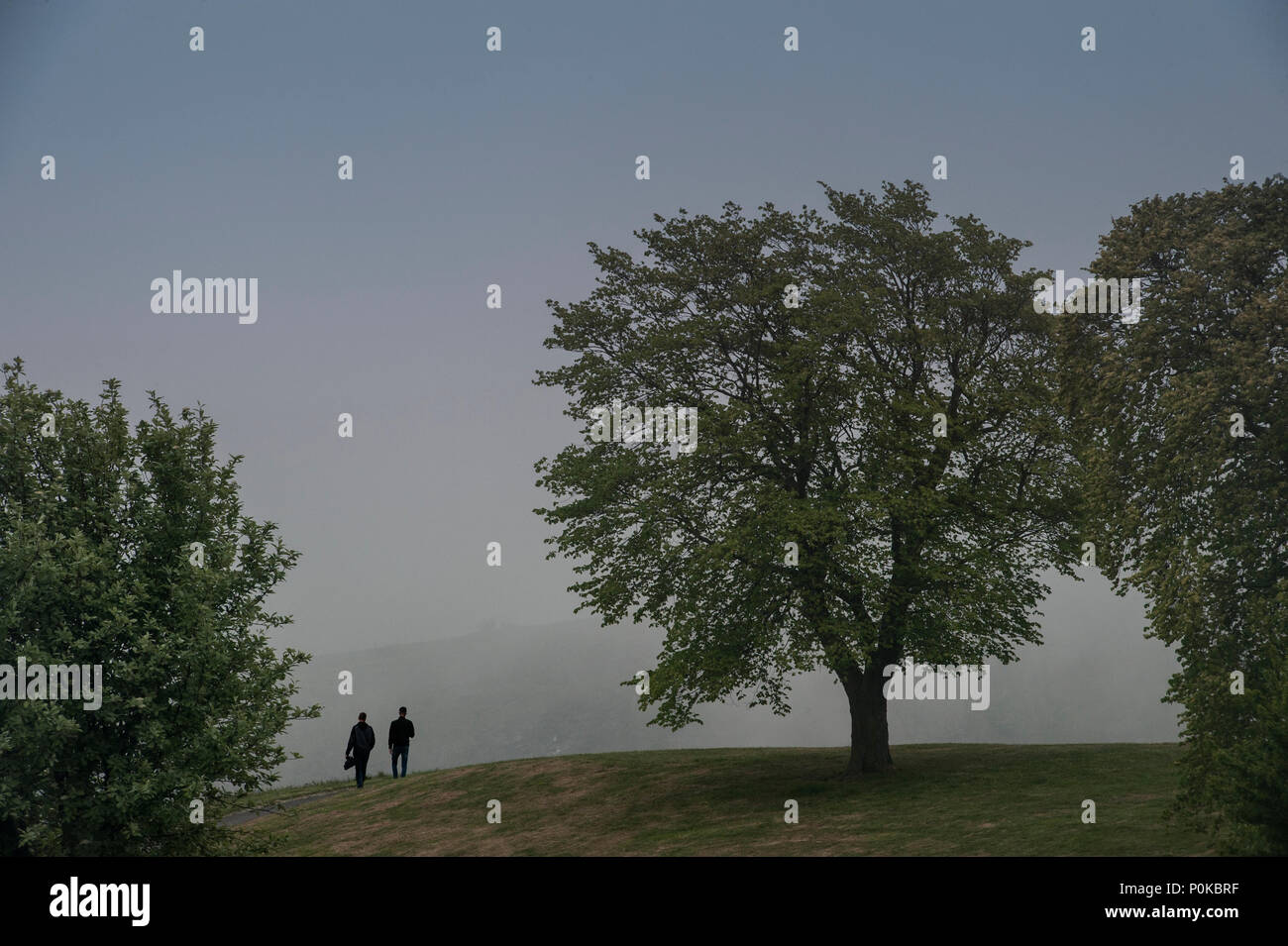 Zwei Menschen laufen an der Spitze der Carlton Hill auf einem nebligen Tag Stockfoto