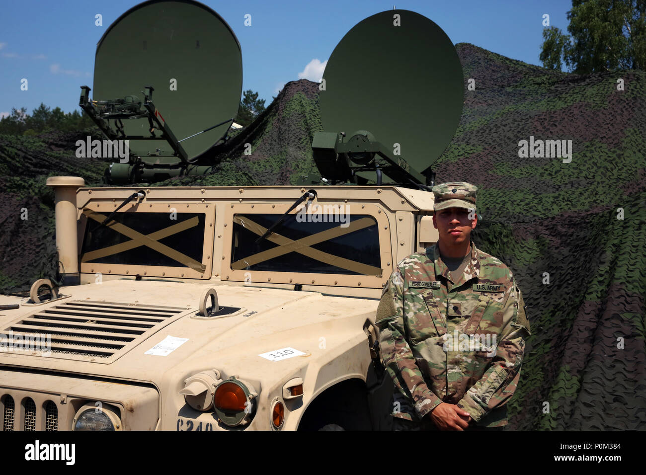 Us-Armee SPC. Antonio Perez Gonzalez, eine sichere mobile Anti-Jam zuverlässige taktische Terminal oder SMART-T, Bediener, Charlie Company zugeordnet, 44th Expeditionary Signal Battalion, 2nd Theater Signal Brigade, steht neben einer SMART-T die Kommunikation unterstützen Sabre Streik auszuüben, 4. Juni 2018 in der Nähe von Powidz, Polen. Sabre Streik ist ein US-Army Europe - LED-Übung mit rund 18.000 Soldaten aus 19 teilnehmenden Nationen in Litauen, Estland, Lettland und Polen von Juni 3-15, 2018. (U.S. Armee Foto durch William B. König) Stockfoto