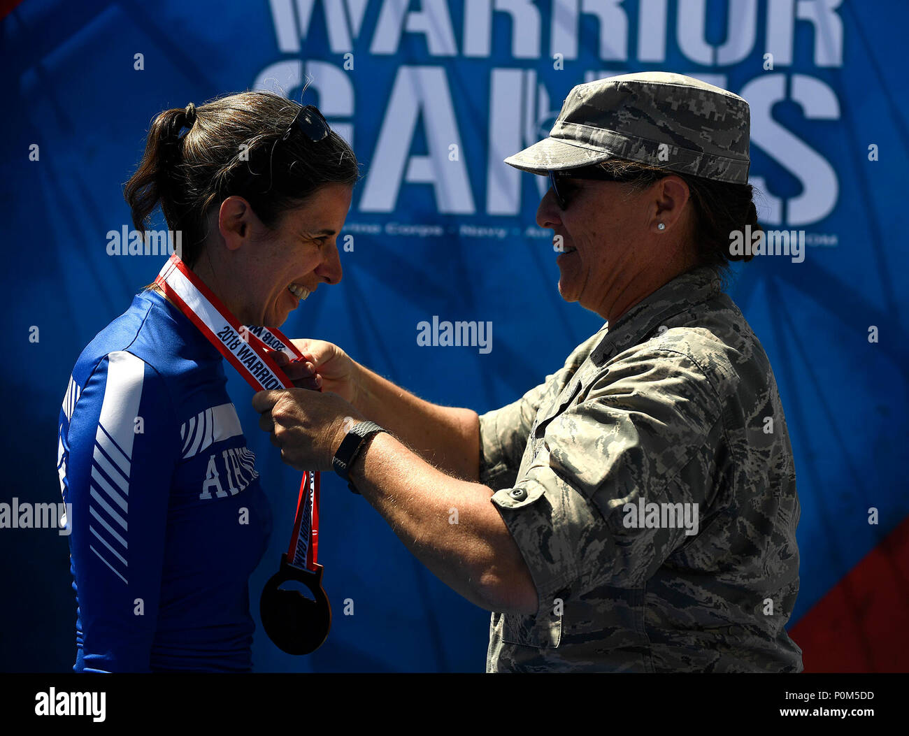 Team Luftwaffe Mitglied Oberstleutnant Audra Lyons, erhält eine Medaille von Brig. Gen. Kathleen Koch, Geschäftsführer der Air Force Services, während ein Verteidigungsministerium Krieger spiele Siegerehrung bei der US Air Force Academy in Colorado Springs, Colorado, 4. Juni 2018. Konkurrieren in der Spiele sind service Mitglieder und Veteranen mit Oberkörper, niedriger - Körper und Rückenmarksverletzungen; Schädel-Hirn-Verletzungen; Sehbehinderung; schwere Krankheiten; und post-traumatischen Stress. Jeder der 39 teilnehmenden Athleten der Luftwaffe wird in einem oder mehreren der 11 Sportarten wie Bogenschießen, Radfahren, Schießen konkurrieren, Sitzen voll Stockfoto