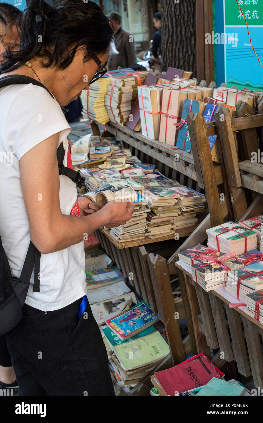Yangzhou, Jiangsu, China. Kunden Bücher bei einem gebrauchten Buch Prüfung stehen, Dong Guan Straße. Stockfoto