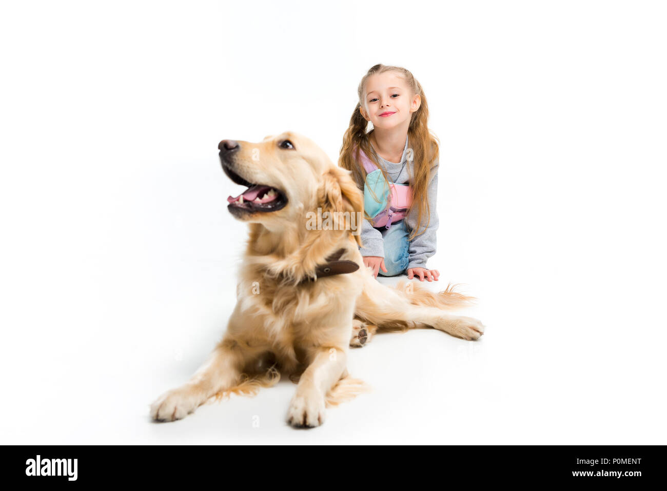 Stilvolle Kind und Hund liegend mit Kragen isoliert auf weißem Stockfoto